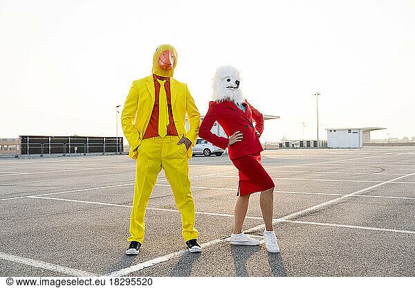 Playful friends in costumes dancing at parking lot