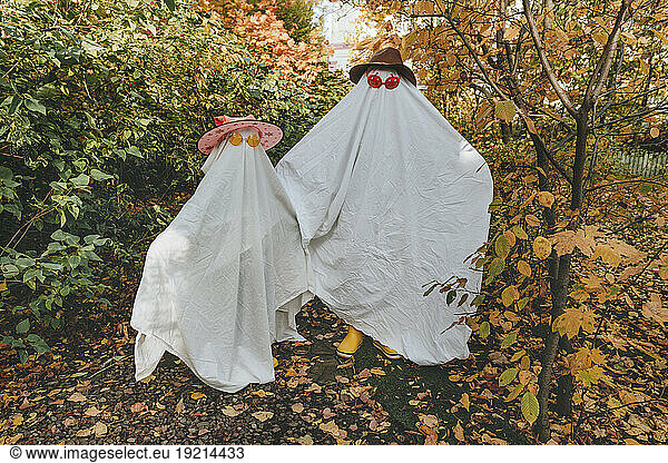 Playful girls in white color costumes standing in garden