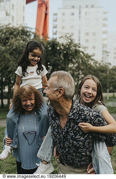 Playful grandparents and grandchildren enjoying at park