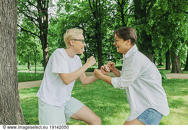 Playful lesbian couple fighting at park