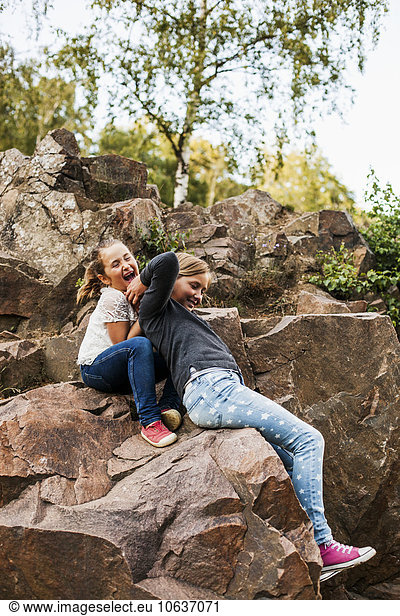 Playful sisters enjoying on rocks
