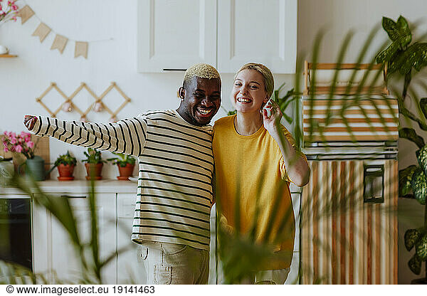 Playful smiling couple gesturing in kitchen