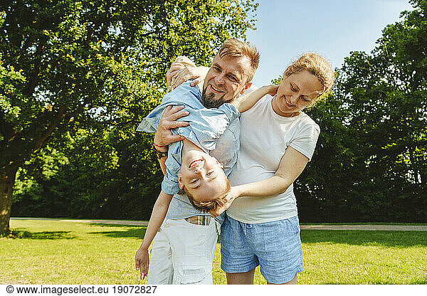 Playful son enjoying with parents on field