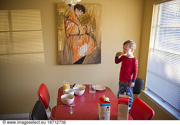 Playing around with a banana while eating breakfast a young boy stands on his chair in Austin  Texas.
