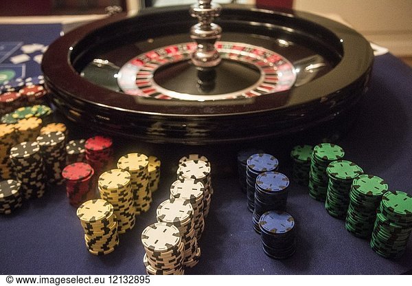 Playing roulette  Roulette game with money around the roulette. The chips of all different colors are lined up waiting to be bought.