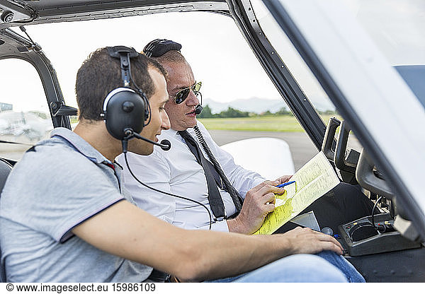 Plot and copilot sitting in sports plane  going through check list