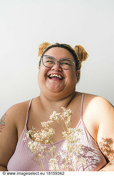Plus sized woman portrait holding flowers laughing