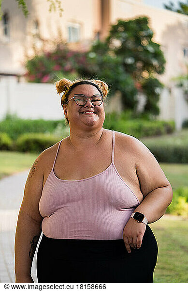 Plus sized woman standing outdoors in active wear smiling