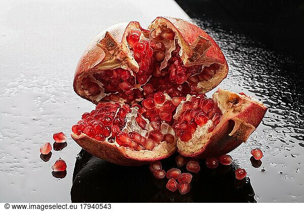 Pomegranate on a glass background with drops of water