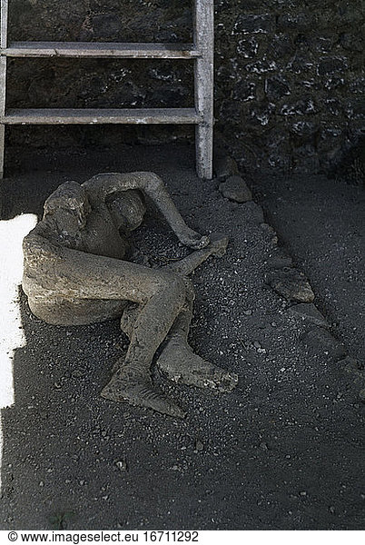 Pompeii (Italy). An inhabitant of Pompeii surprised by the volcanic eruption of Vesuvius 79 AD. Plaster cast of the empty space made by the body under the lava.
Photo.
