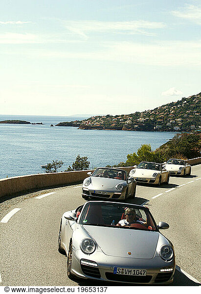 Porche cars driving along the Esterel coast road  Var  Provence  France.