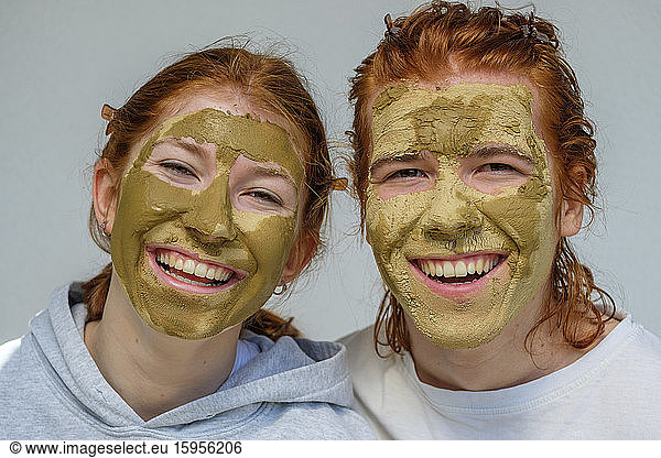 Porträt des lachenden Bruders und der lachenden Schwester mit Gesichtsmasken