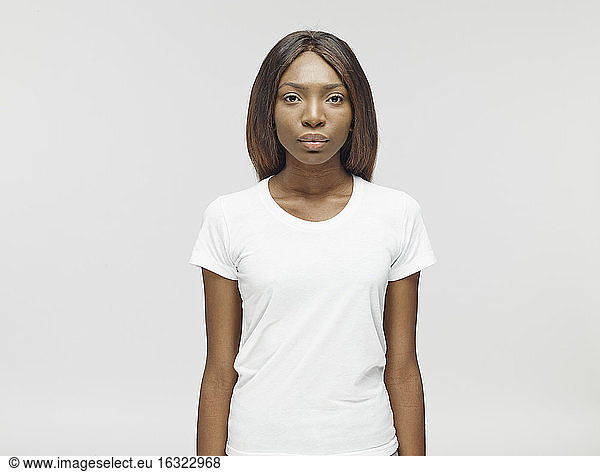 Porträt einer ernst dreinblickenden jungen Frau mit weißem T-Shirt