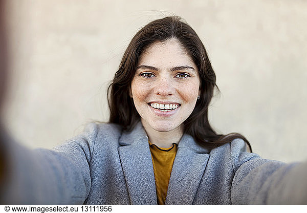 Porträt einer fröhlichen jungen Frau an der Stadtmauer