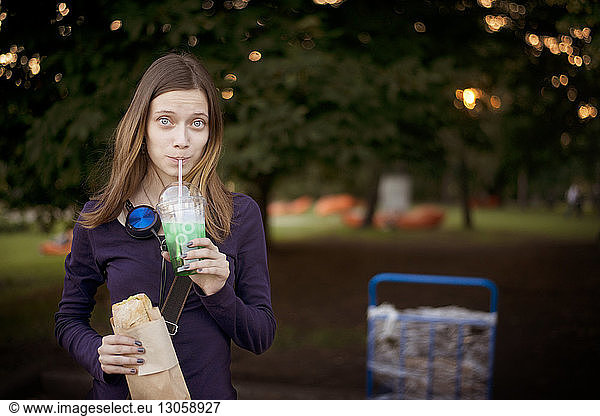 Porträt einer Frau bei einem Drink im Park