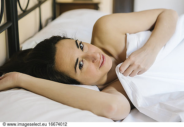 Porträt einer Frau im Bett mit Blick in die Kamera