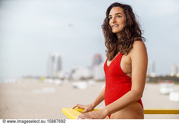 Porträt einer Frau im roten Badeanzug auf einer Rettungsschwimmerhütte in Miami Beach  Miami  Florida  USA