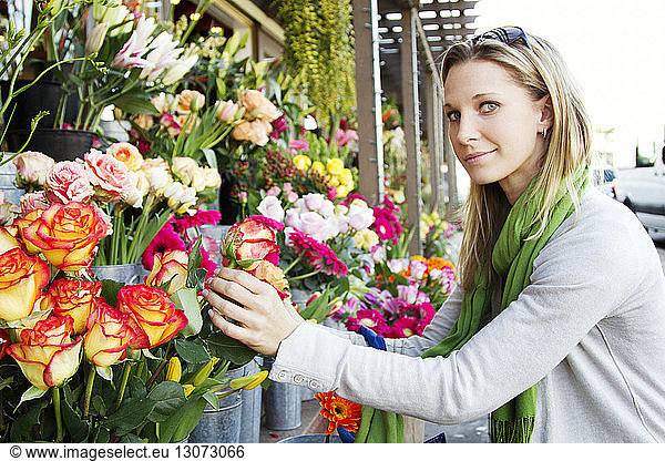 Porträt einer Frau mit Blumen am Marktstand