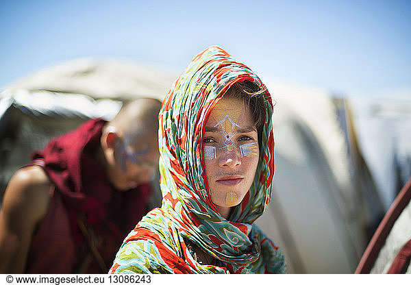 Porträt einer Frau mit Gesichtsbemalung mit Kopftuch bei einer traditionellen Veranstaltung