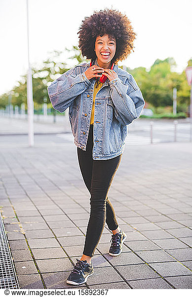 Porträt einer glücklichen jungen Frau mit Afrofrisur in der Stadt