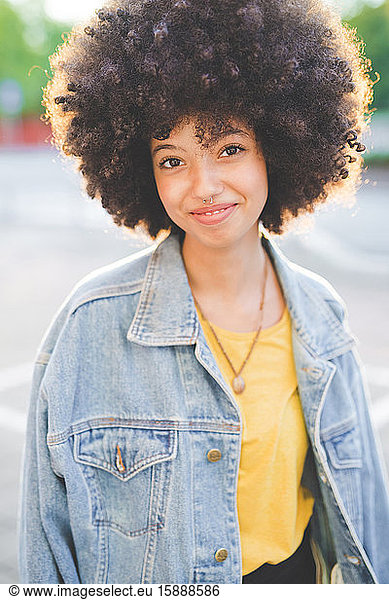 Porträt einer jungen Frau mit Afrofrisur in der Stadt