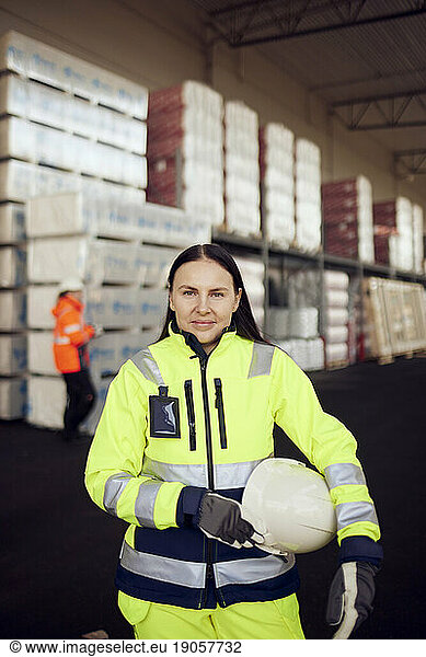 Porträt einer lächelnden Arbeiterin in Arbeitsschutzkleidung in der Industrie