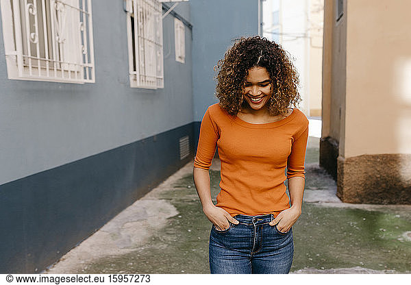 Porträt einer lächelnden Frau in orangem Pullover