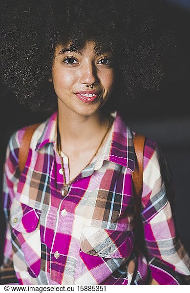 Porträt einer lächelnden jungen Frau mit Afro-Frisur
