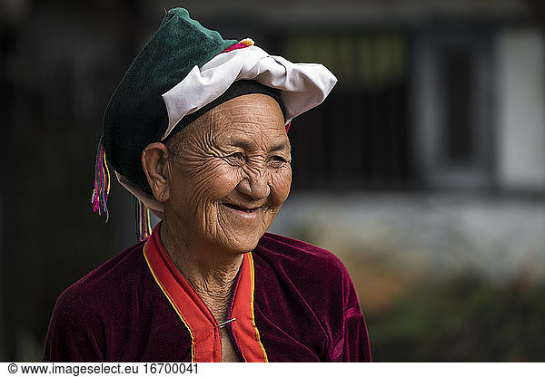 Porträt einer lächelnden älteren Frau vom Stamm der Palong mit Kopfbedeckung  in der Nähe von Hsipaw  Myanmar