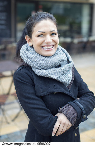 Porträt einer lächelnden mittleren erwachsenen Frau im Outdoor-Café