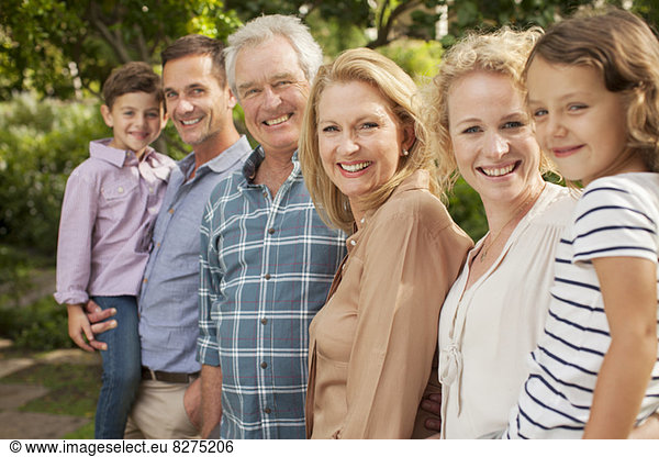 Porträt einer Mehrgenerationen-Familie  die im Freien lächelt