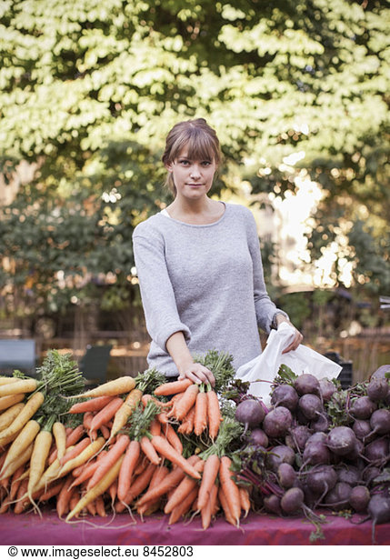 Porträt einer selbstbewussten Gemüseverkäuferin am Stand