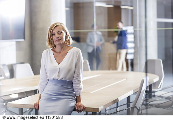 Porträt einer selbstbewussten Geschäftsfrau am Konferenztisch