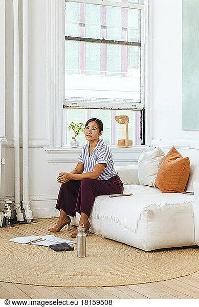 Porträt einer selbstbewussten jungen Geschäftsfrau auf dem Sofa sitzend