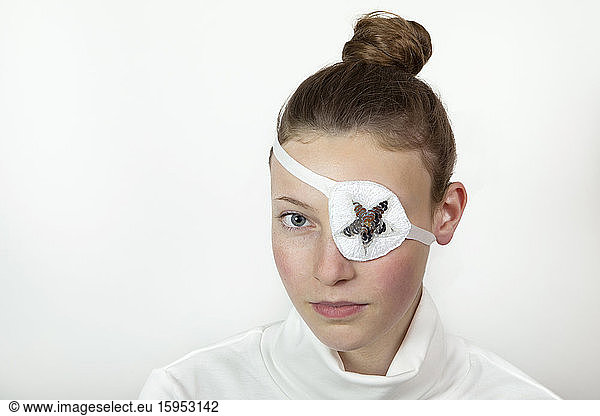 Porträt einer Teenagerin mit Brötchen mit Augenklappe
