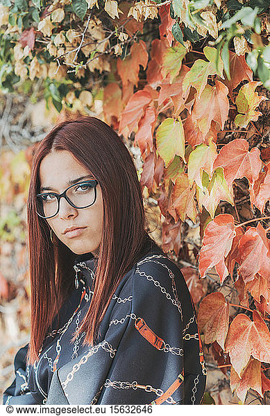 Porträt einer Teenagerin mit gefärbten roten Haaren vor der Begrünung im Herbst