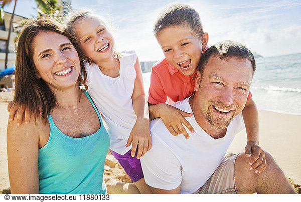 Porträt einer vierköpfigen Familie  die ihren Sommerurlaub in Waikiki Beach genießt; Honolulu  Oahu  Hawaii  Vereinigte Staaten von Amerika'.