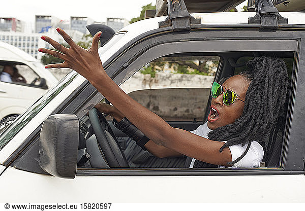Porträt einer wütenden Frau mit Dreadlocks beim Autofahren