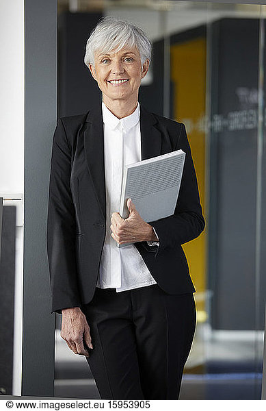 Porträt einer zufriedenen älteren Geschäftsfrau im schwarzen Hosenanzug