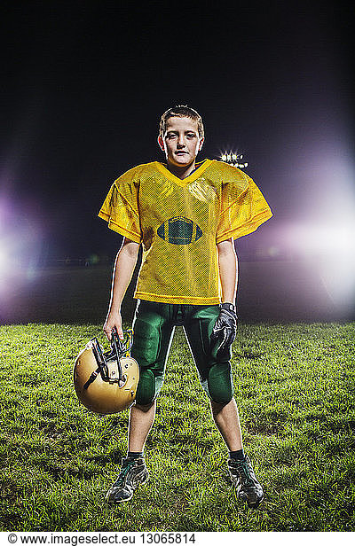 Porträt eines American-Football-Spielers auf dem Spielfeld gegen den Himmel