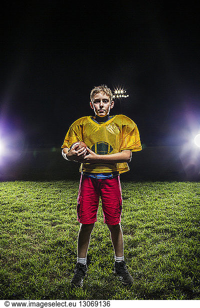 Porträt eines American-Football-Spielers mit Ball auf dem Spielfeld