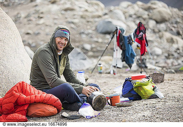 Porträt eines Bergsteigers  der im Lager eine Mahlzeit einnimmt.