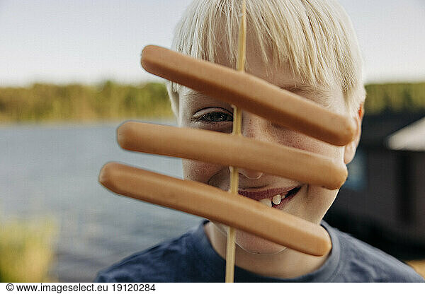 Porträt eines blonden Jungen mit Würstchen im Ferienlager