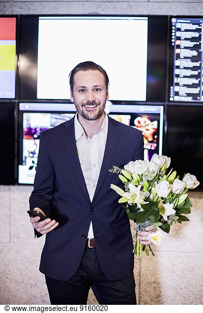 Porträt eines erfolgreichen Geschäftsmannes mit Blumenstrauß im Amt