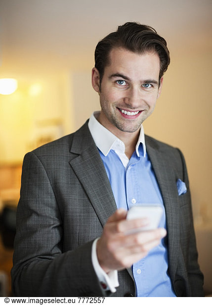 Porträt eines fröhlichen Mannes im Anzug mit Handy