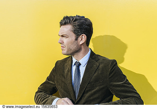 Porträt eines Geschäftsmannes vor gelber Wand