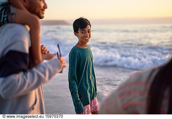 Porträt eines glücklichen Jungen am Meeresstrand mit Familie