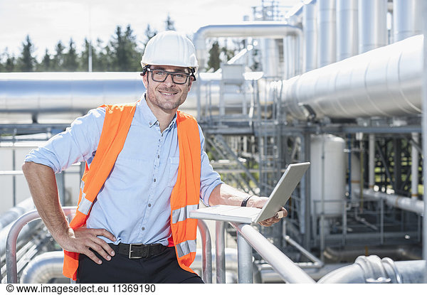 Porträt eines Ingenieurs bei der Arbeit am Laptop in einem geothermischen Kraftwerk