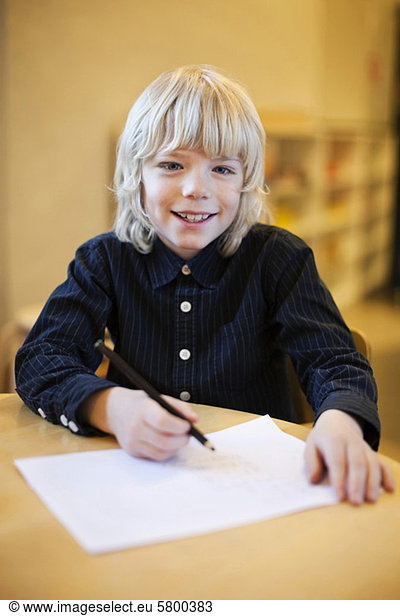 Porträt eines Jungen  der zu Hause Hausaufgaben macht