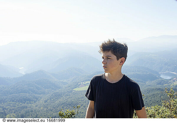Porträt eines jungen Mannes mit schwarzem T-Shirt vor einem Gebirge
